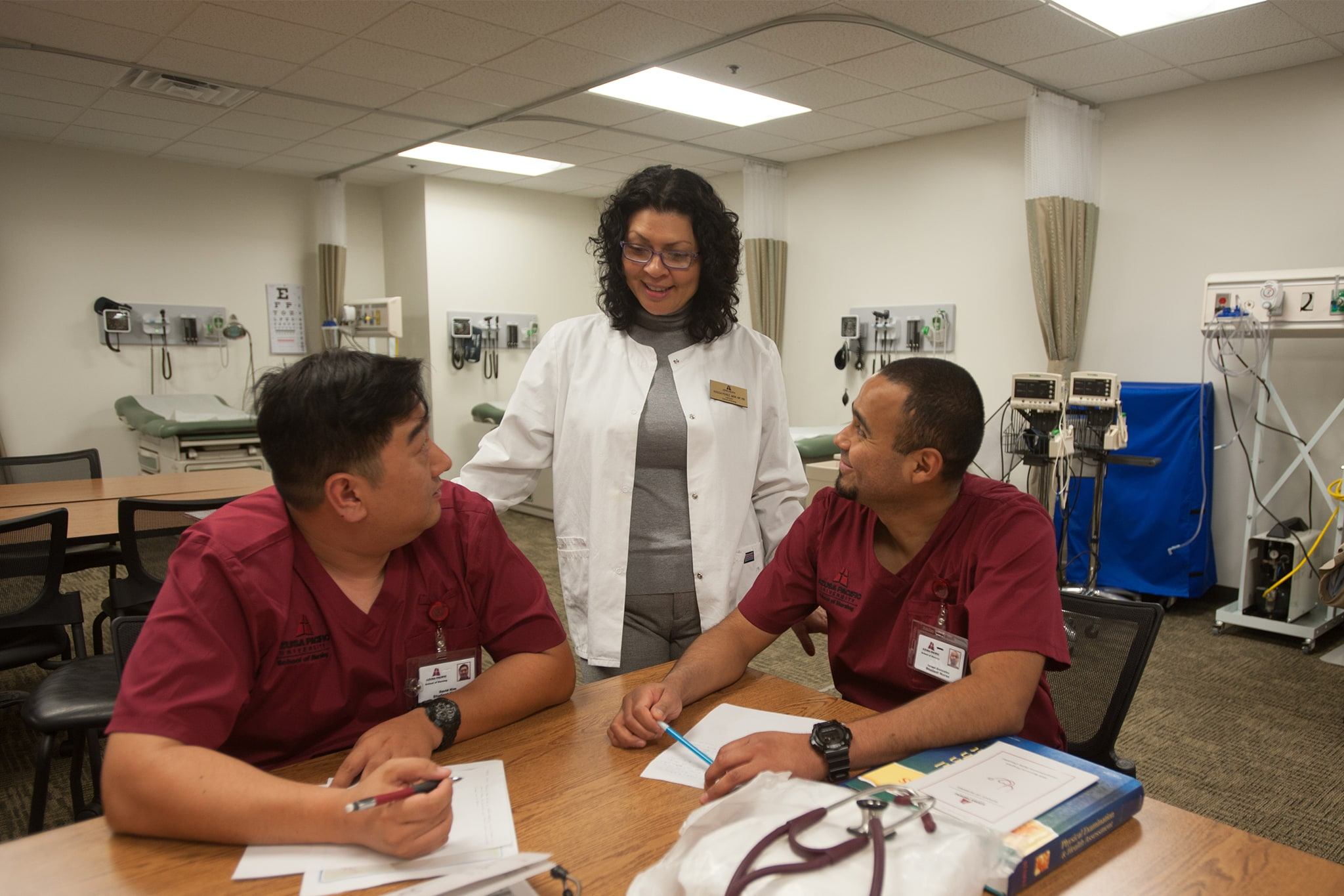 Nurse instructor helping two students