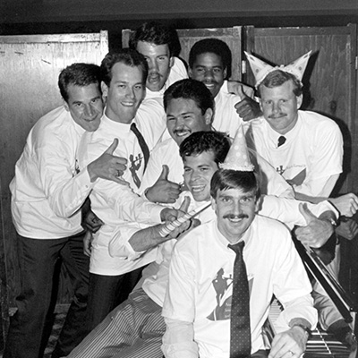 men apu students wearing white shirts and smiling. Image is in black and white