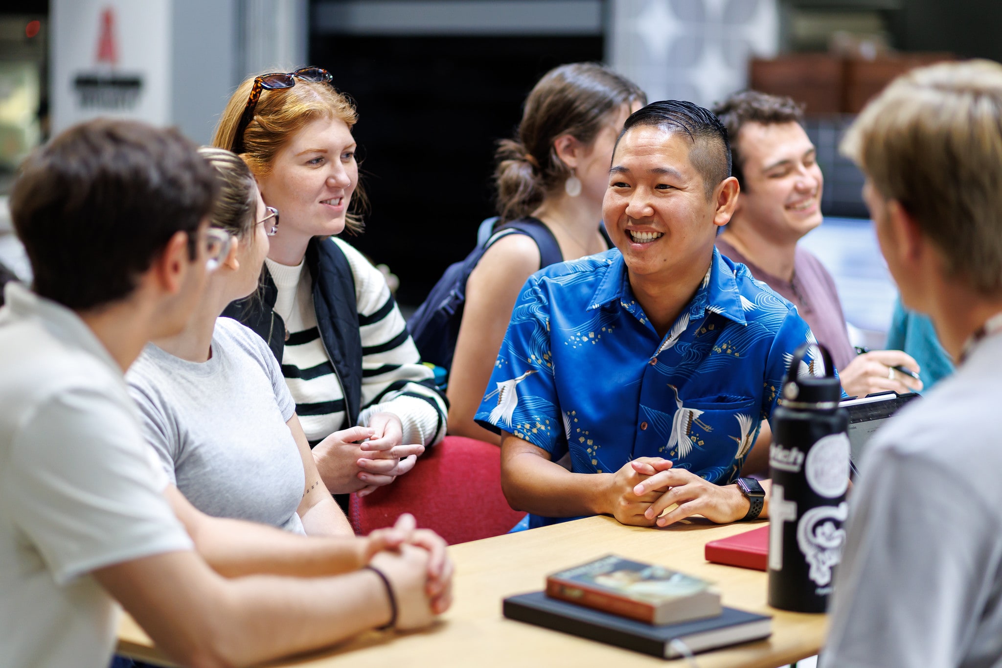 students smiling and hanging out around a table