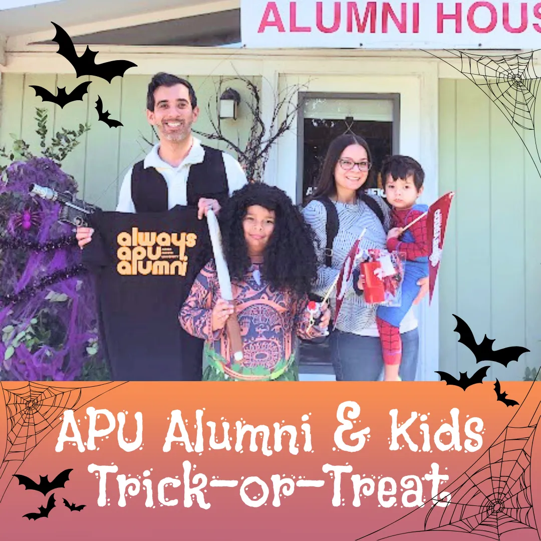 a family wearing customes in front of the alumni house