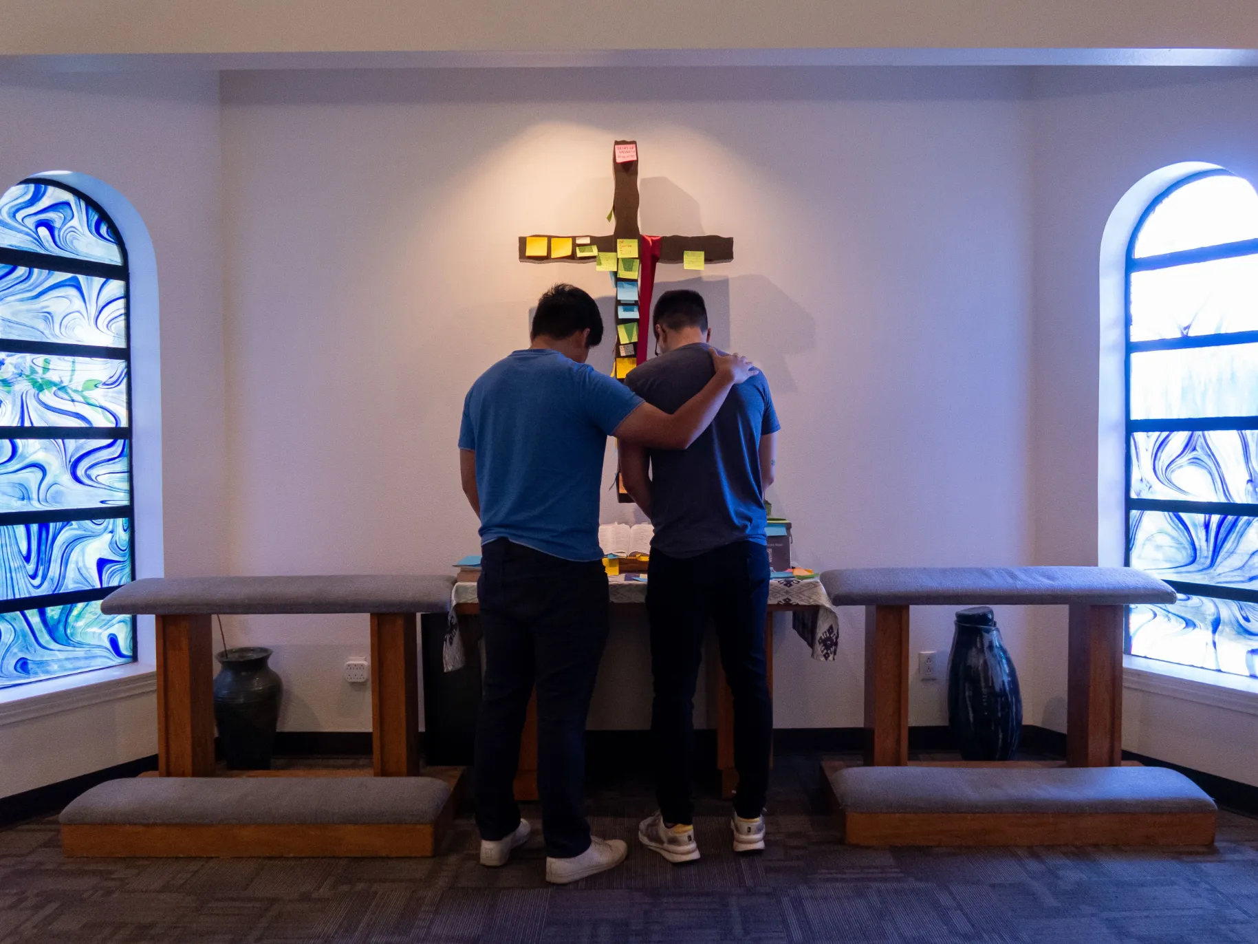 Two APU students pray for each other in the Prayer Chapel.