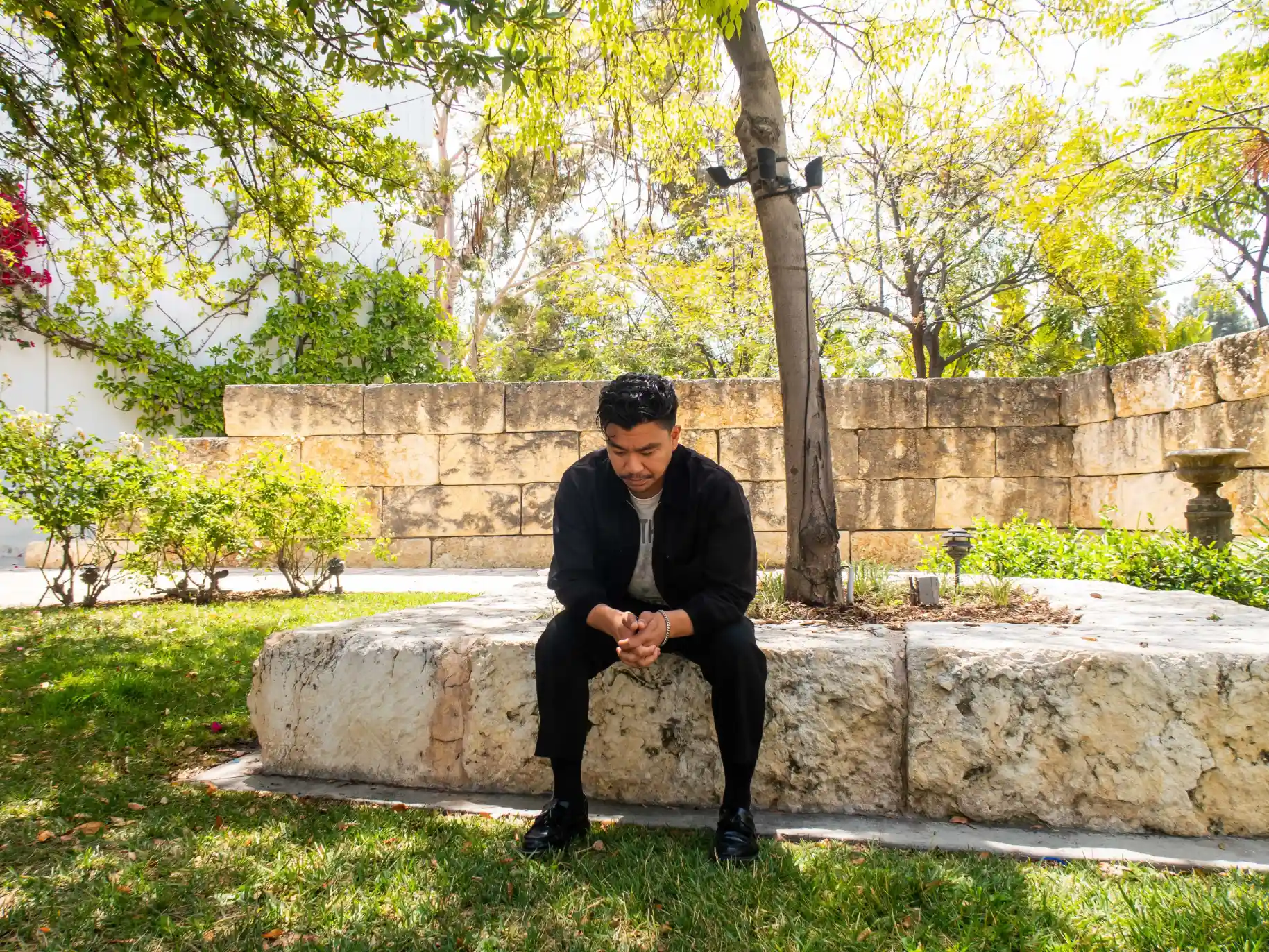 A student sits and prays in the Prayer Garden.