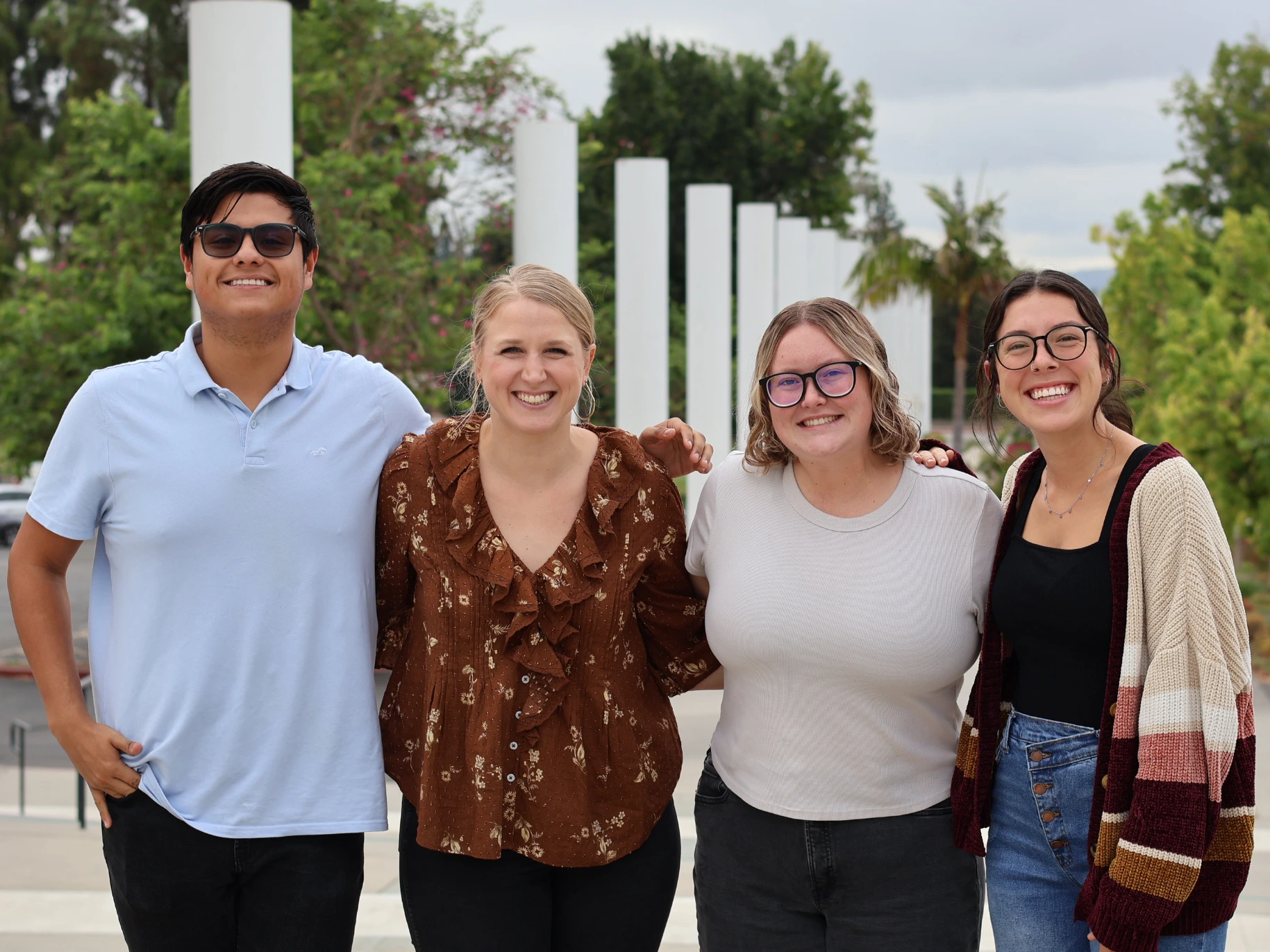 Three students in APU's preaching lab smile alongside Annelyse Thomas.