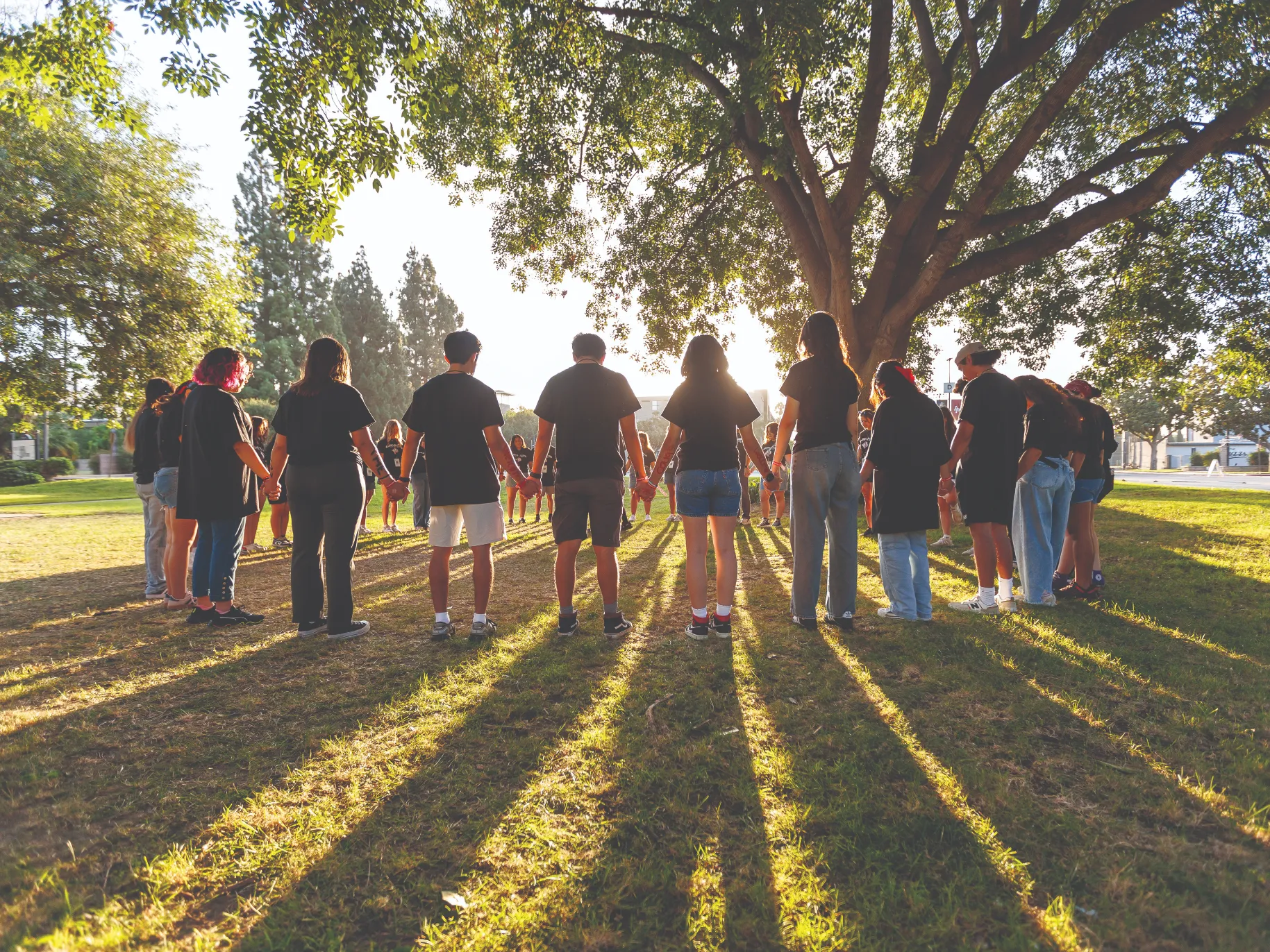 Students hold hands in a prayer circle