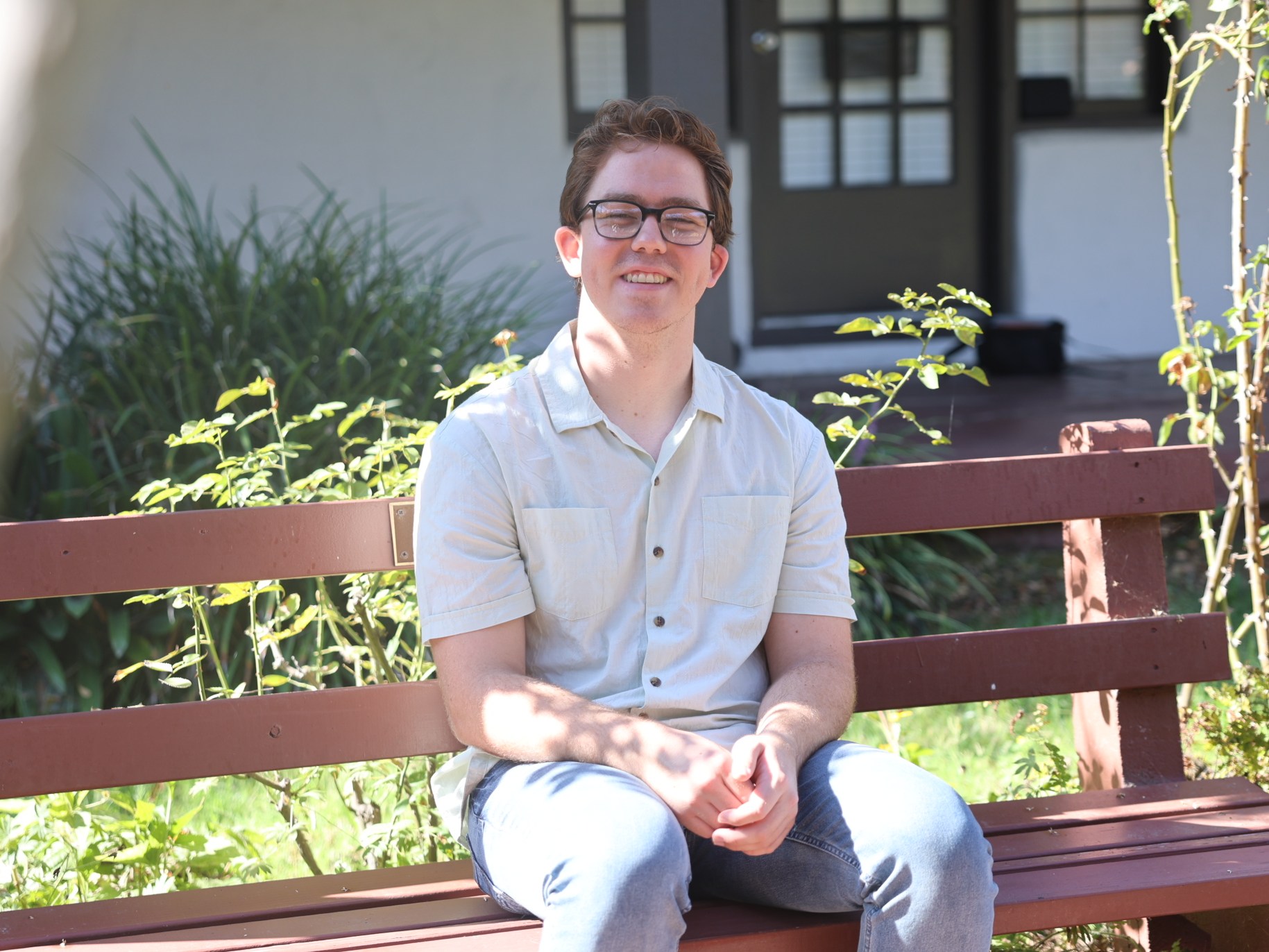 Ben Doerksen sitting on a bench smiling.