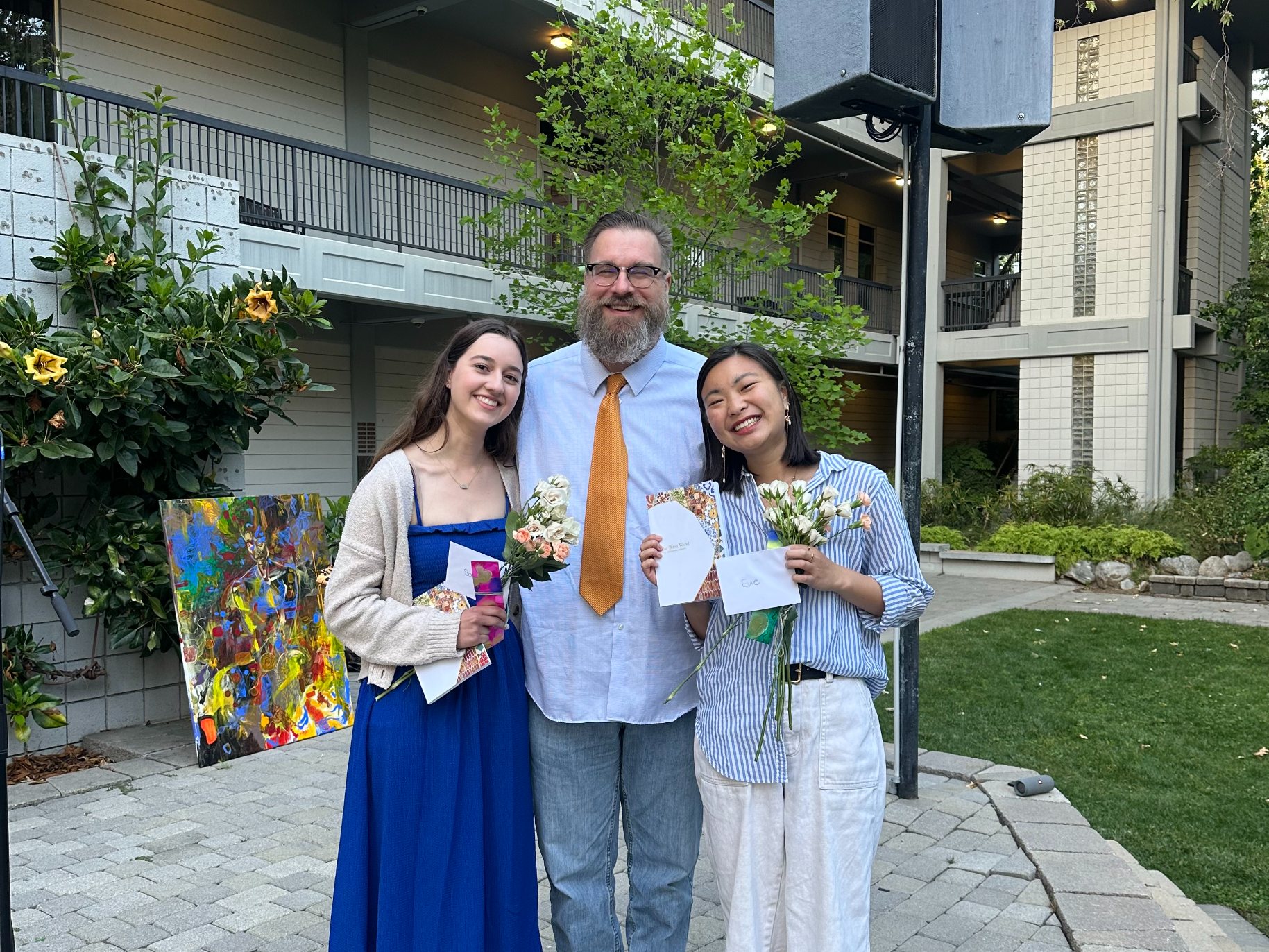 Saundri and Evie Huang, West Wind co-editor-in-chief, smile with professor Michael Dean Clark