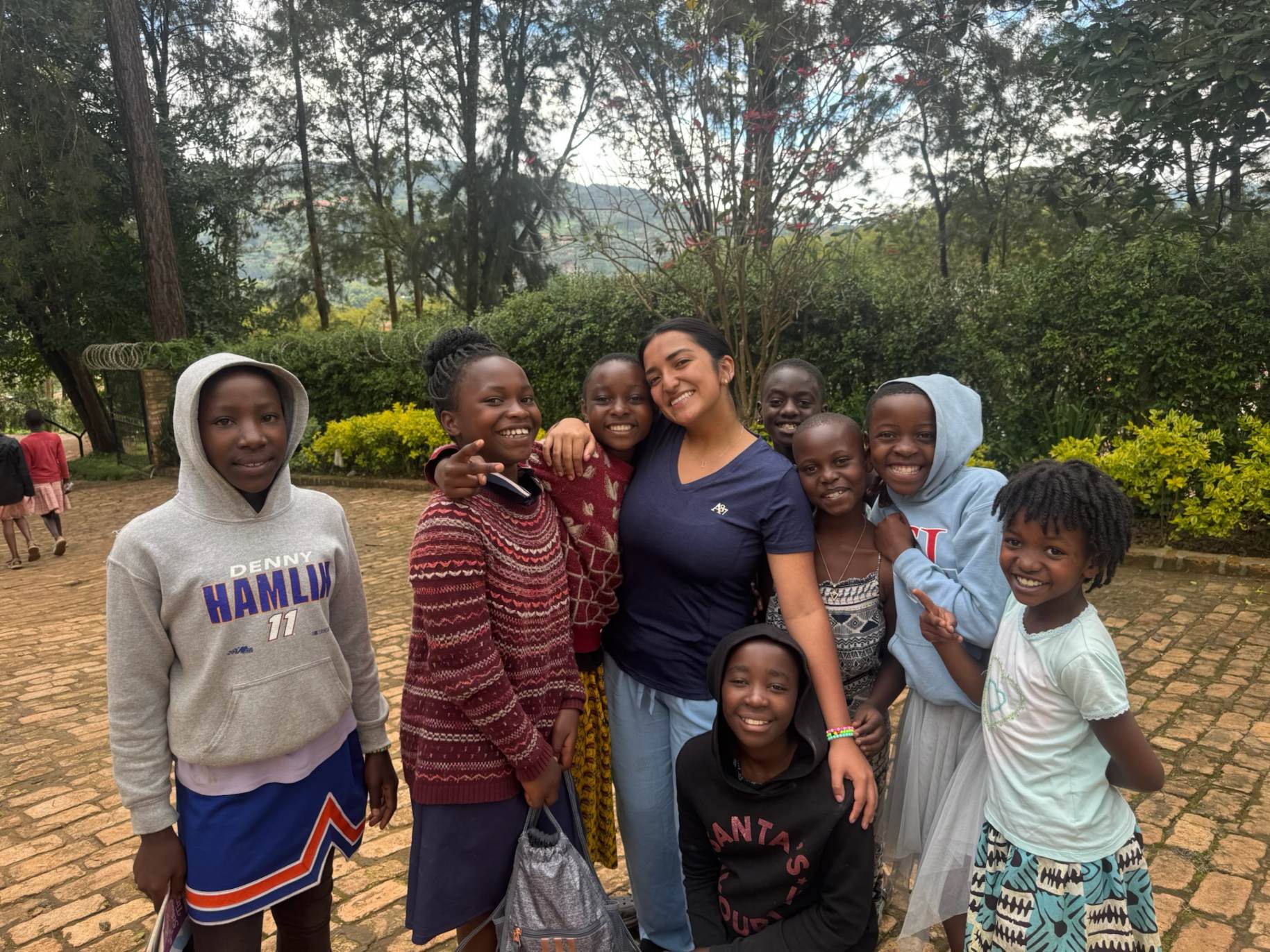 Julissa Sanchez stands with children in Uganda.