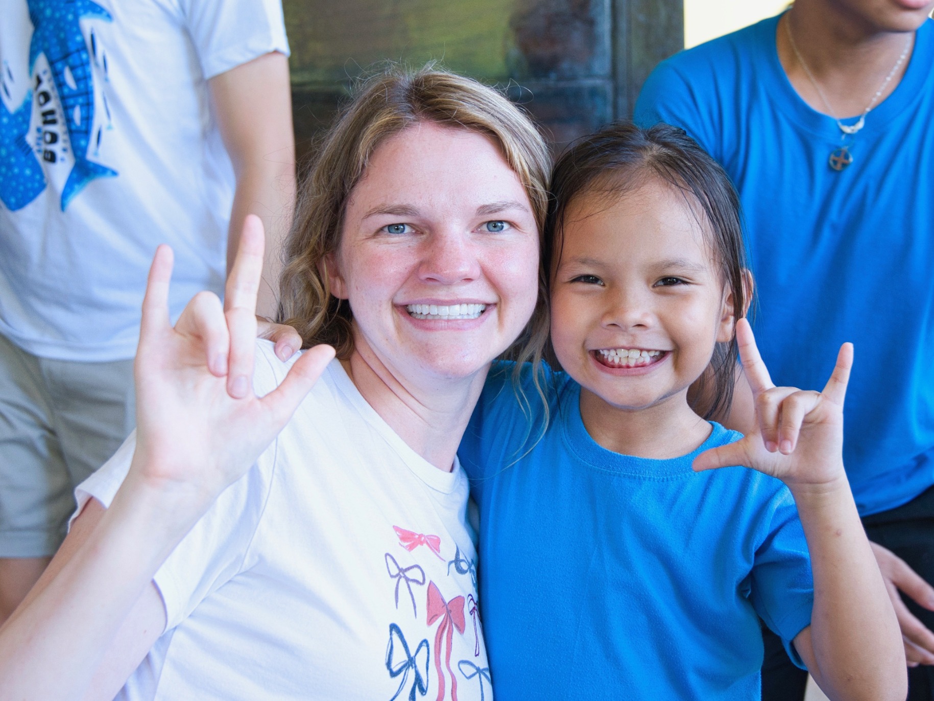 Two people smiling, signing I love you 