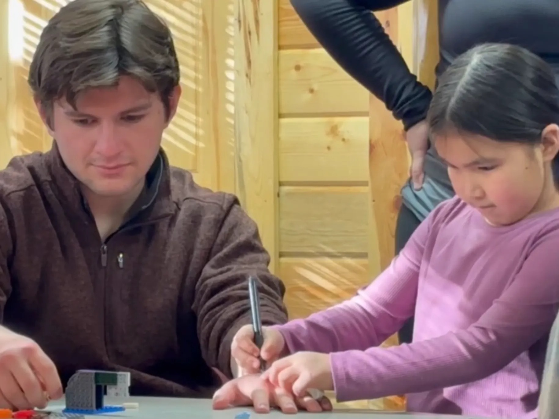 Camden Patterson ’28 helping child draw.
