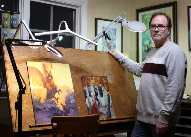 Chuck in front of his paintings