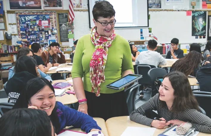 professor wearing green shirt and helping students in class