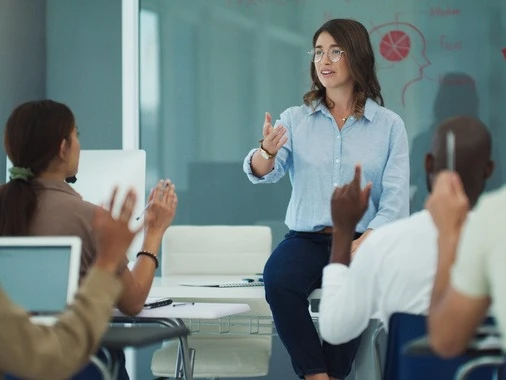 Woman stands before class teaching 