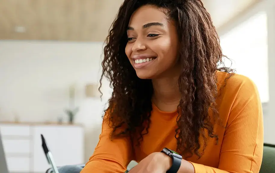 Prospective college student smiling while reviewing college application information on a laptop