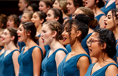 women's orchestra wearing blue dress and singing