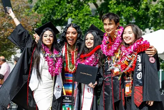students smiling with their cap and gown