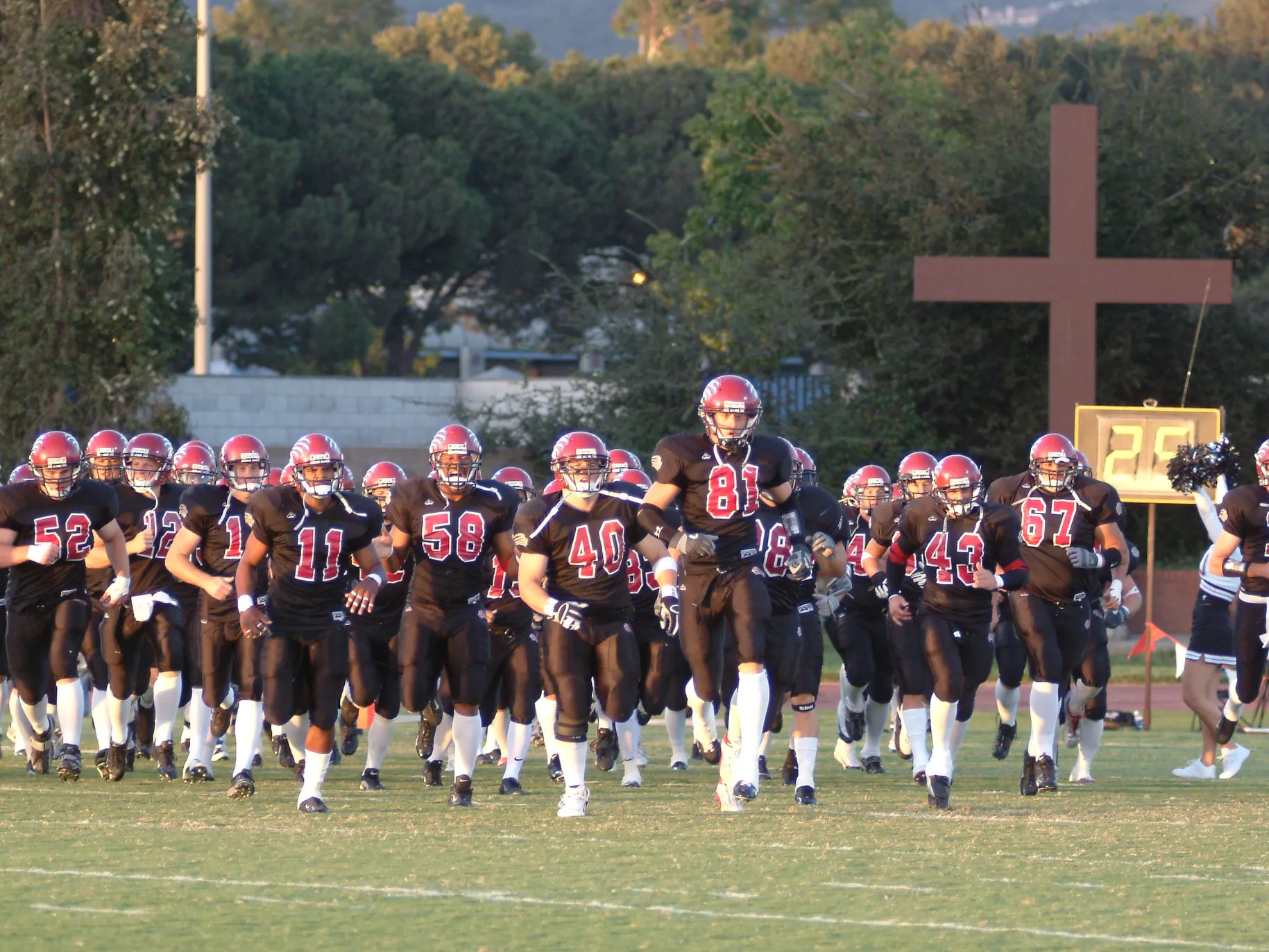 APU football players rush onto the field before a game