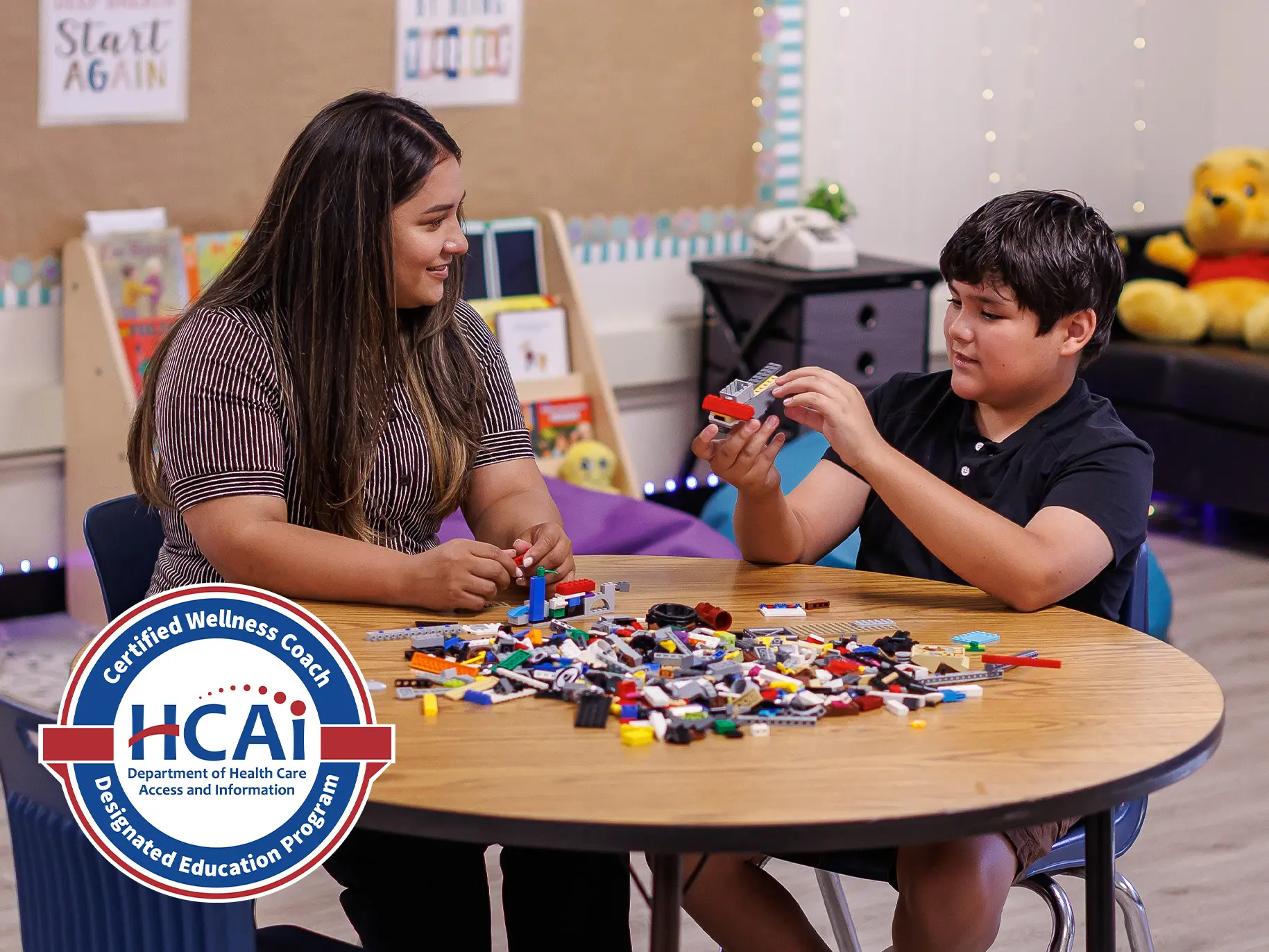 A social work student engages with a child in play therapy in a classroom