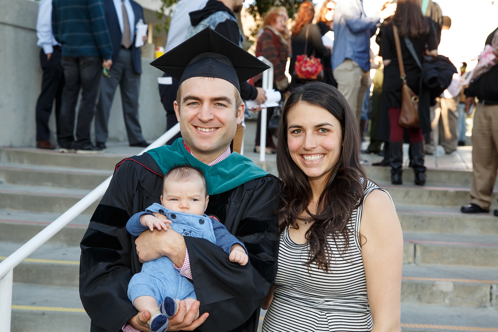 Student in cap and gown with this young family