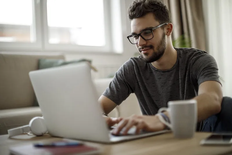 Male student using laptop at home