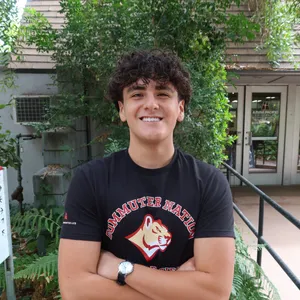 Matthew smiling with his arms crossed