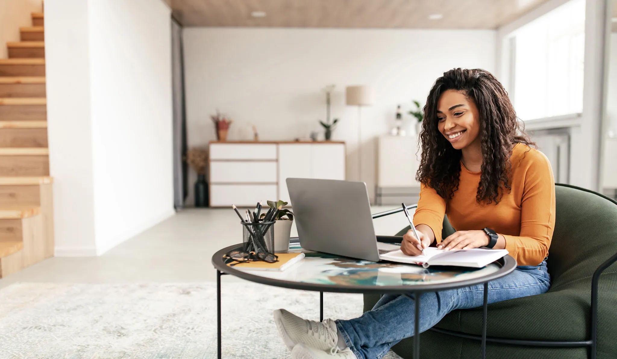 Online nursing student takes notes while studying on a laptop at home. Select 88 more words to run Humanizer.