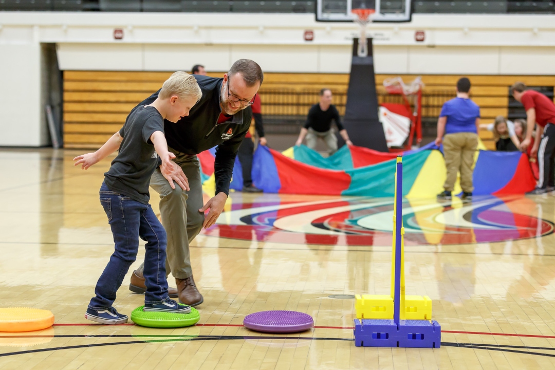 Educator leading child in obstacle course