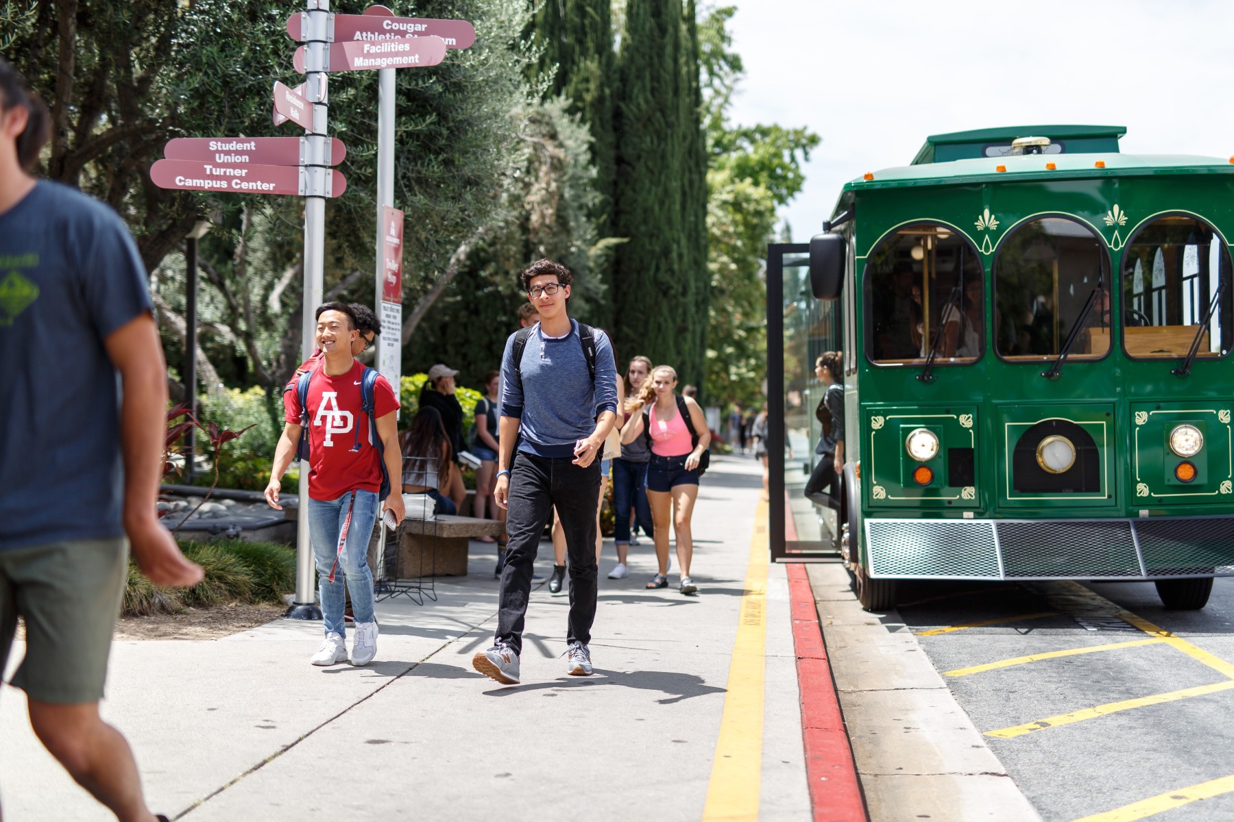 students walking from red apu trolley