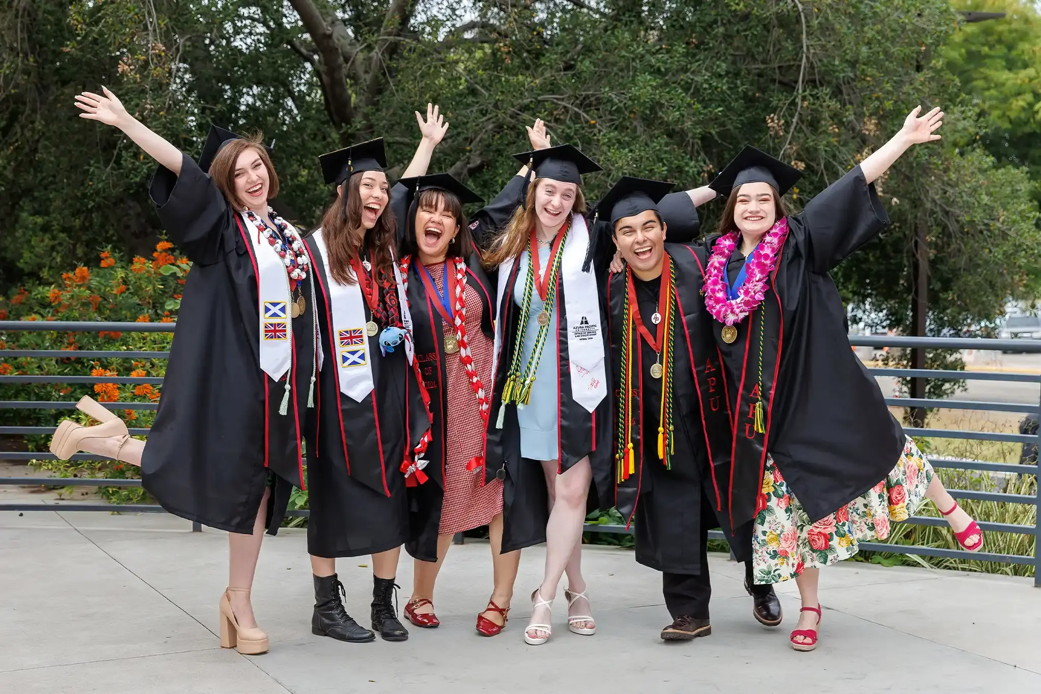 Azusa Pacific University graduates celebrate together in caps and gowns after commencement.
