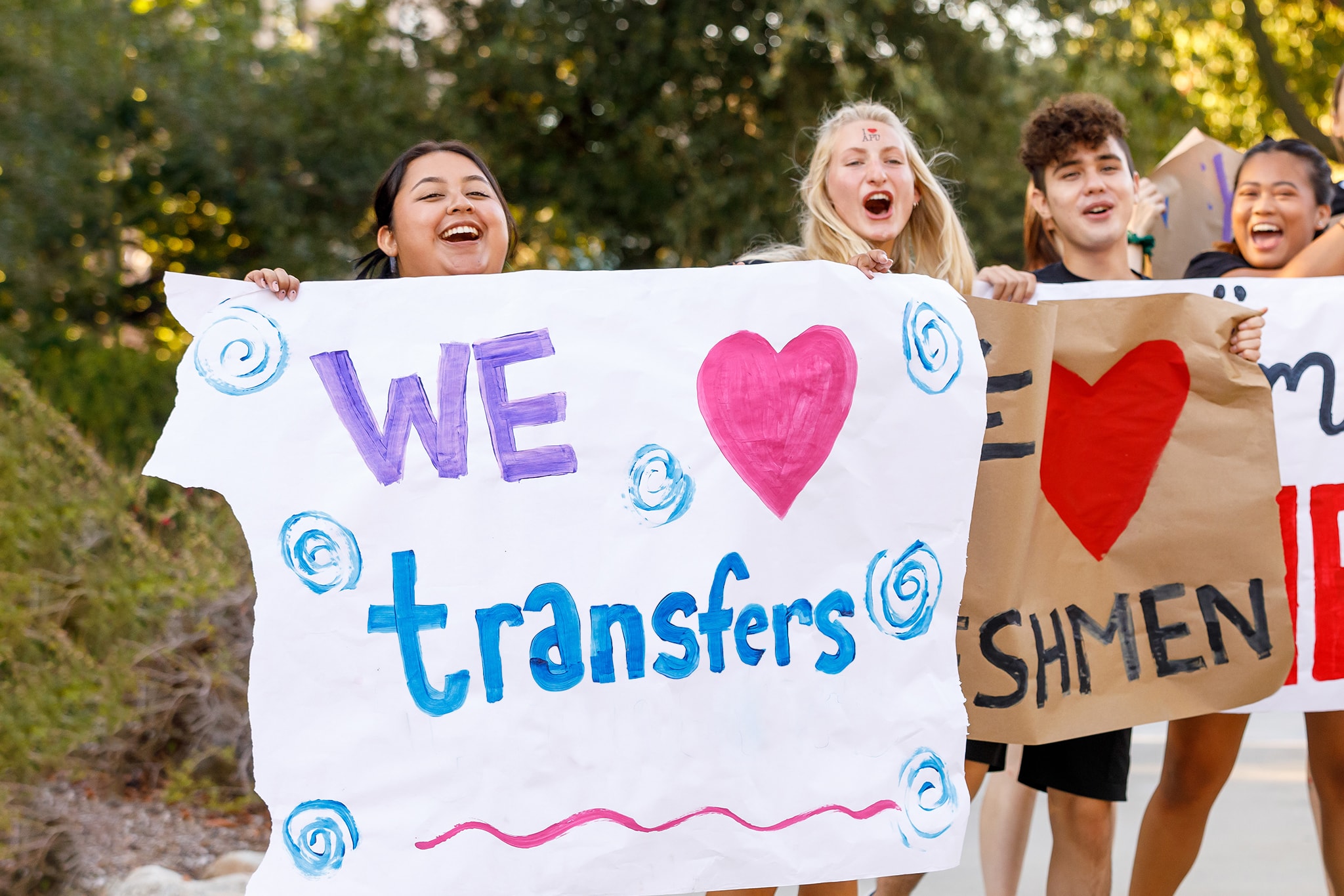 Student holding a We Heart Transfers poster