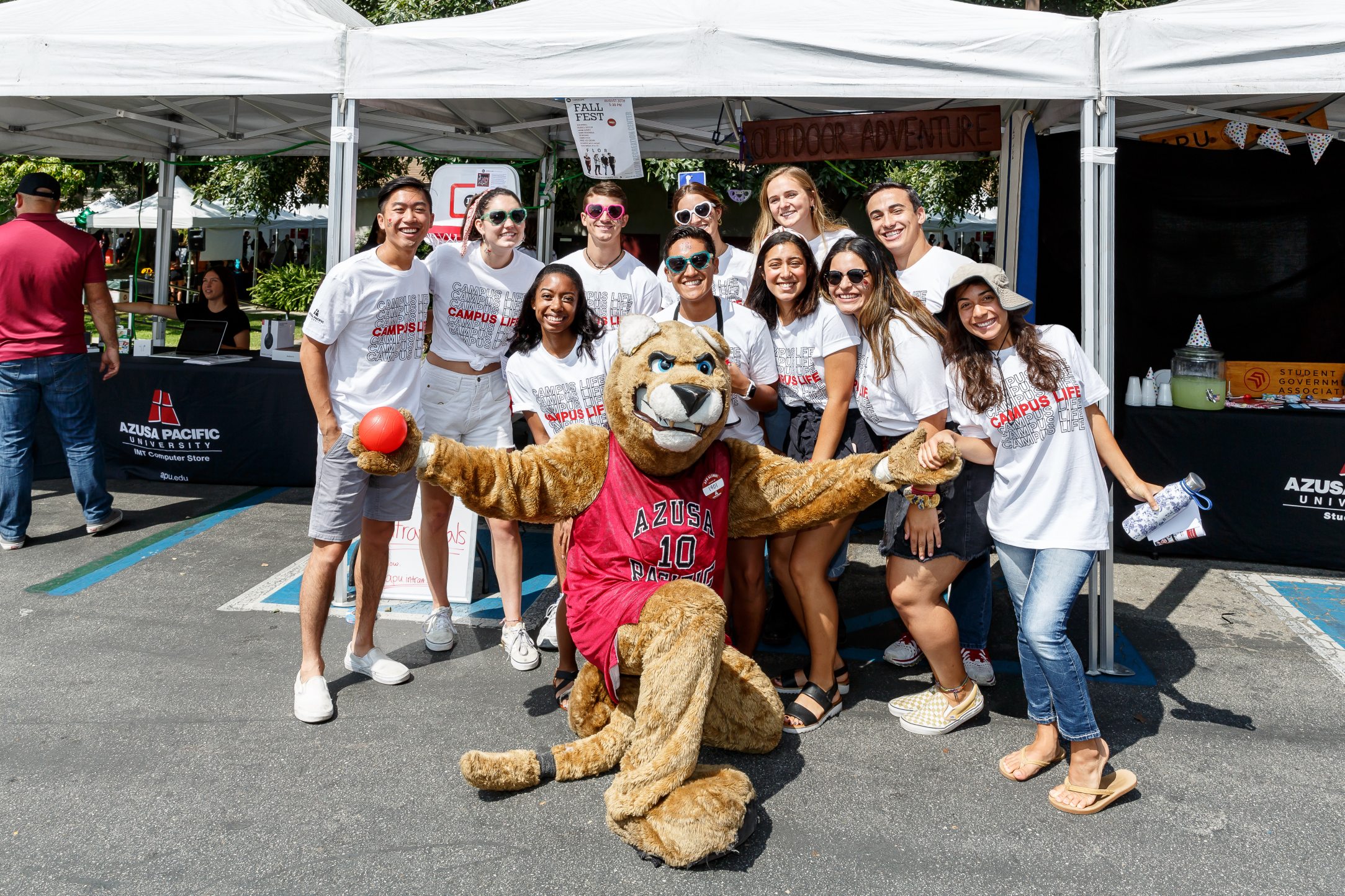 apu students smiling and gathering with cougar mascot during event