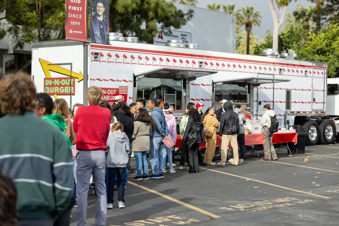 in and out food truck with a line of students