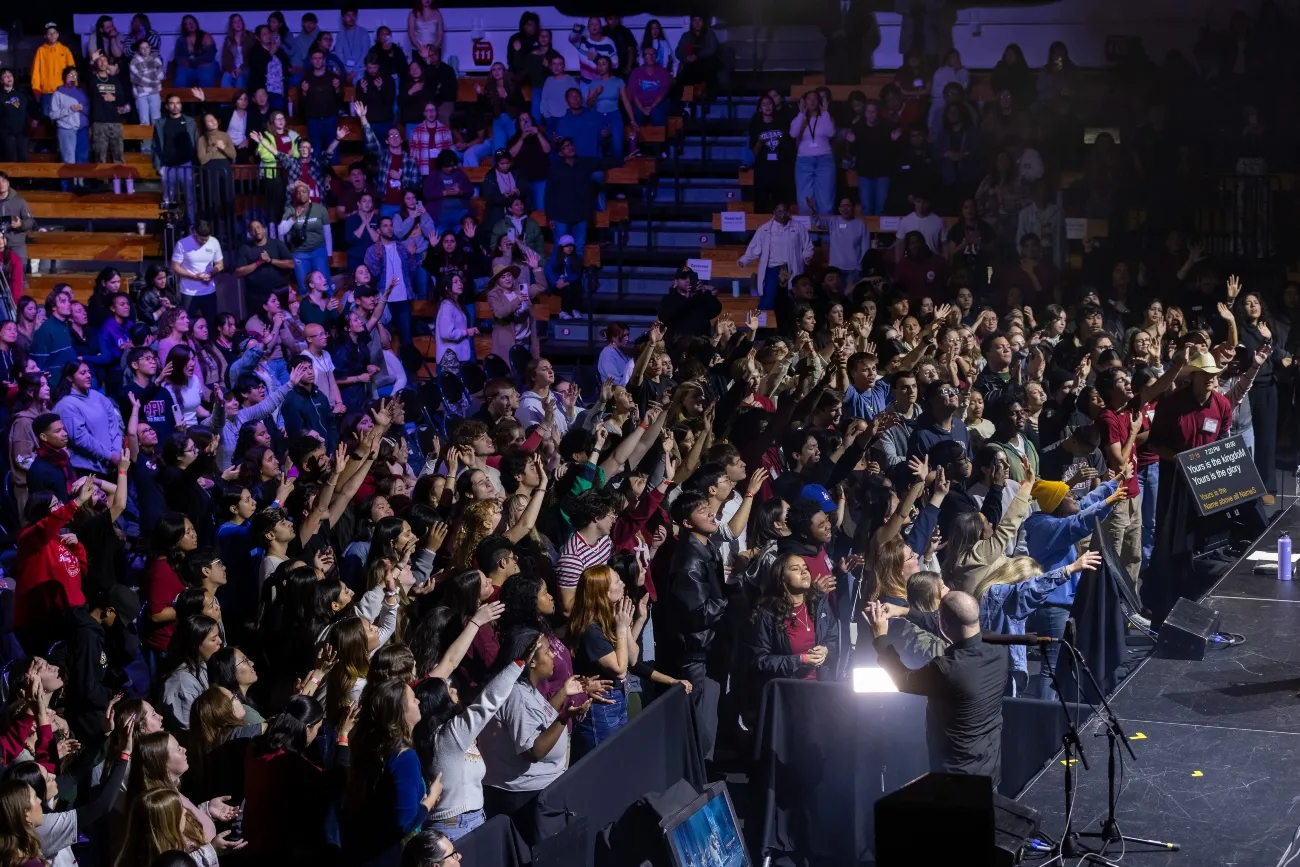 Student worshiping in a crowd