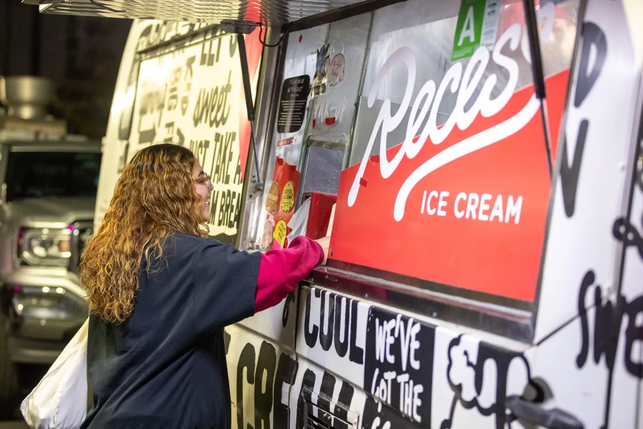 Student in front of ice cream truck smiling