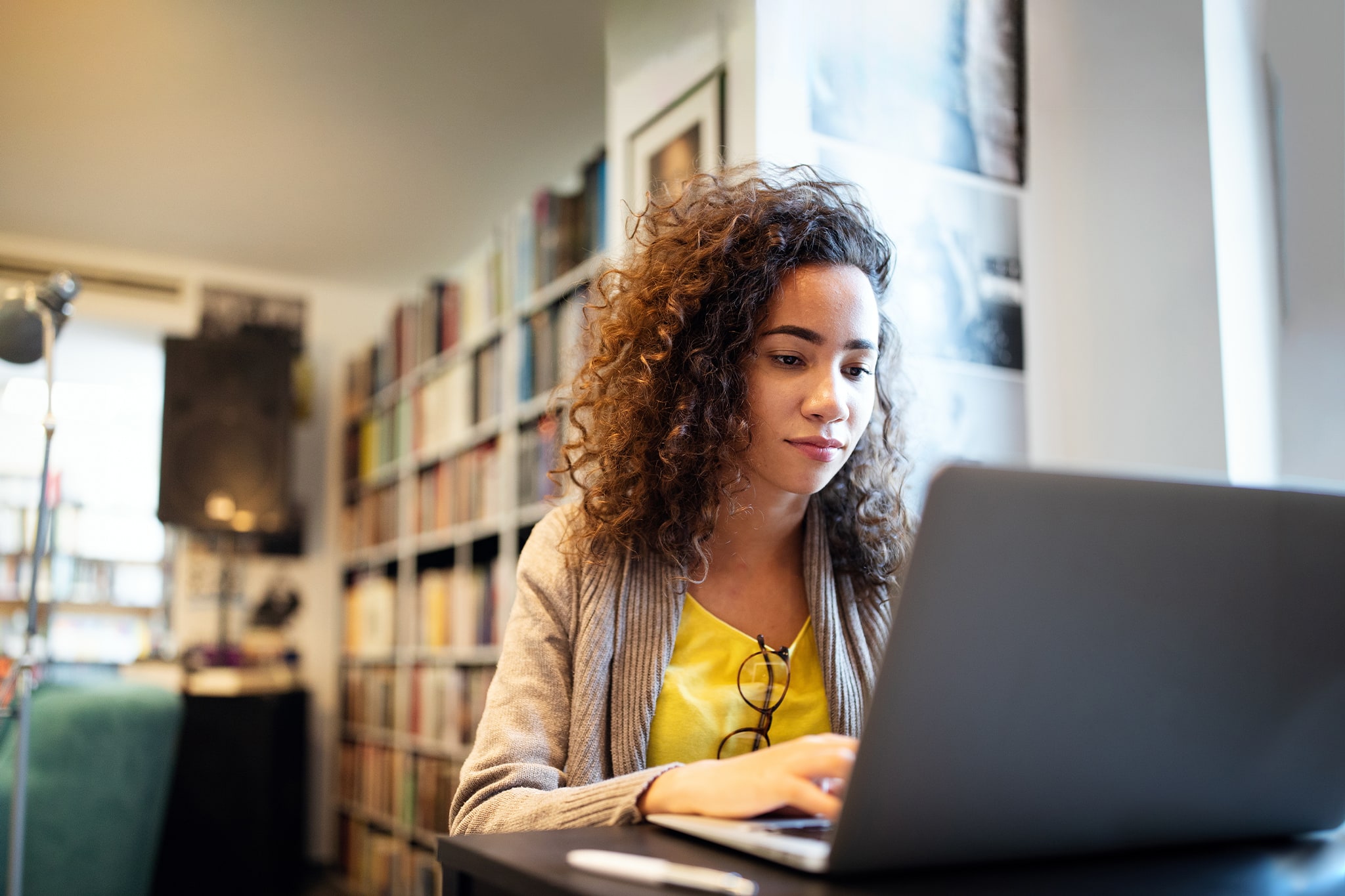 students wearing yellow t-shirt and using her laptop