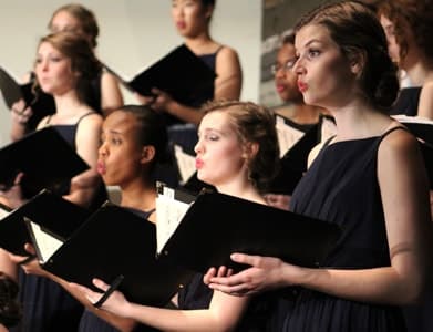 Image of choral's members wearing black clothes and singing for the choral.